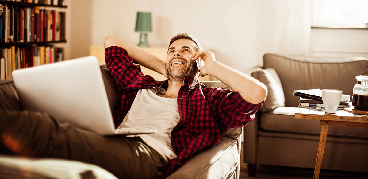 Mature man talking on mobile phone at home